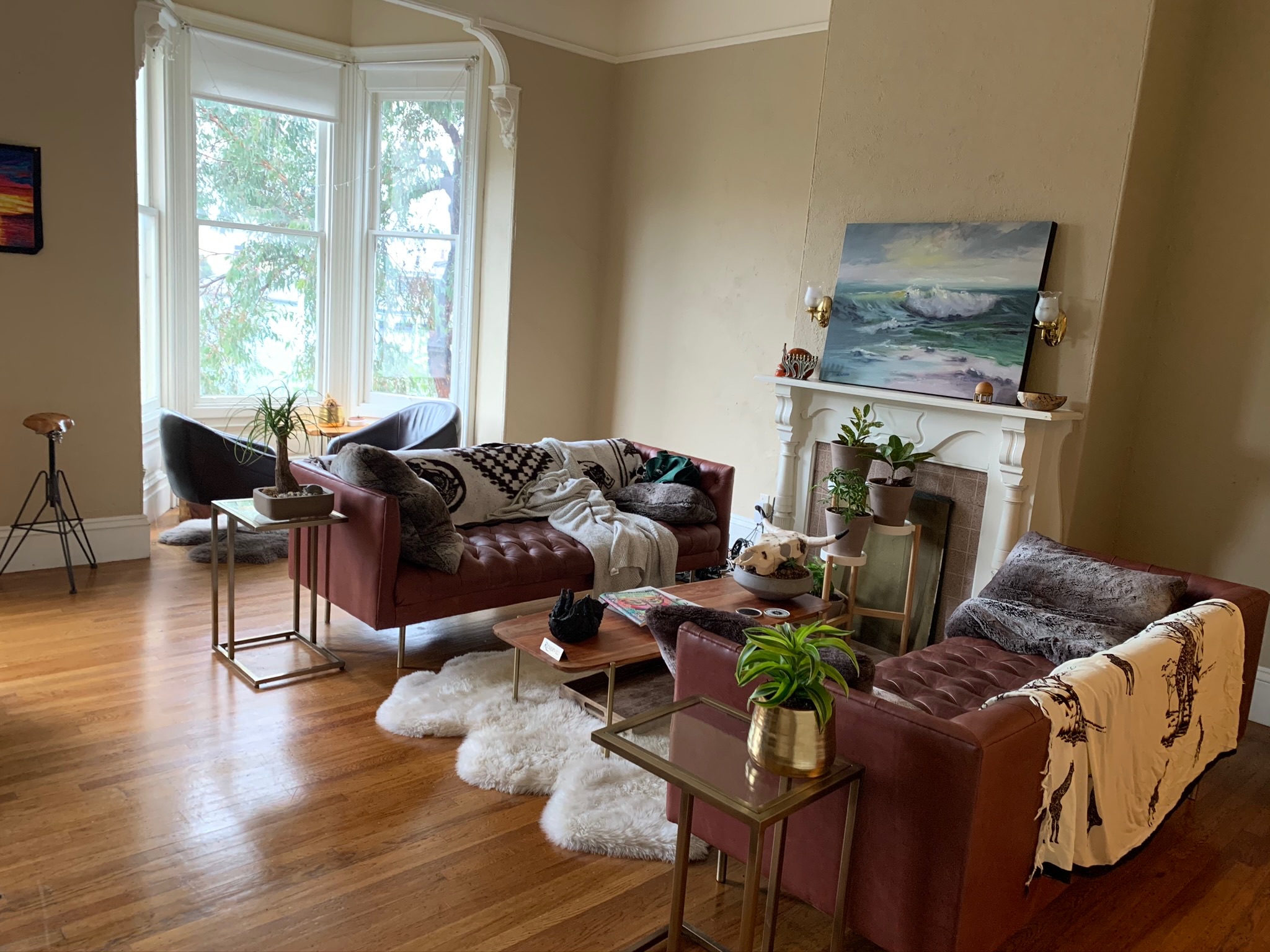 Living room with leather sofas and ocean painting above fireplace