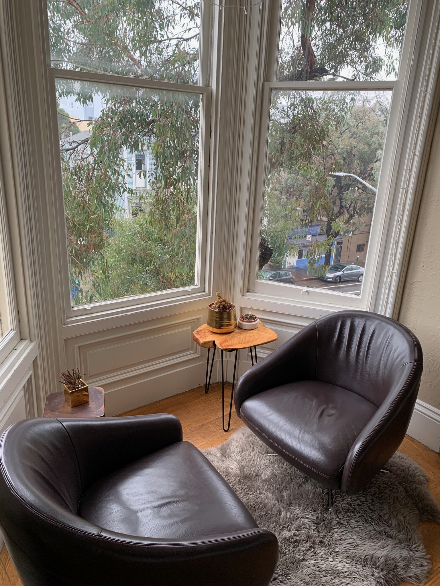 Bay window nook with black leather chairs and street view