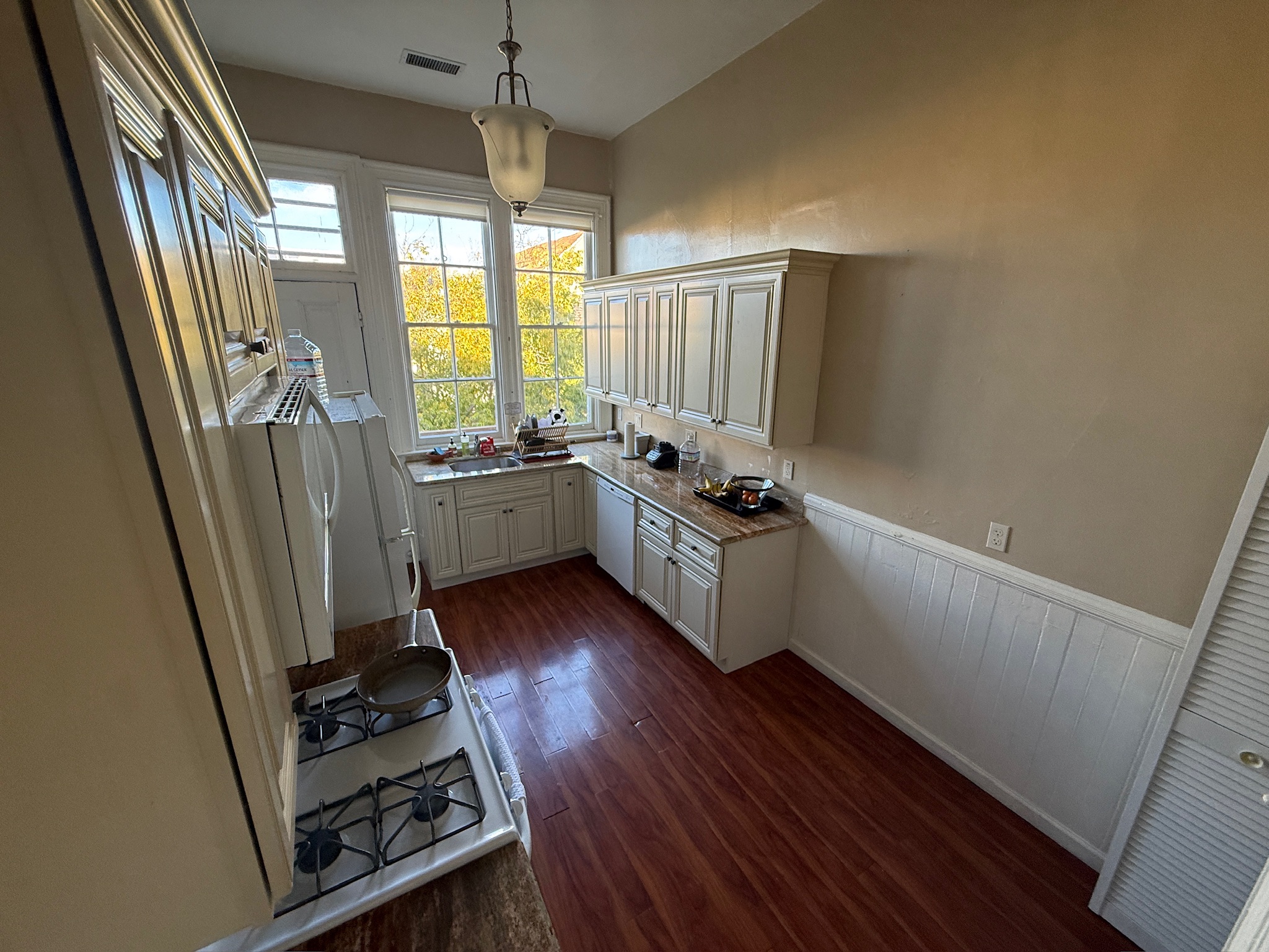 Bright kitchen with white cabinets and large windows