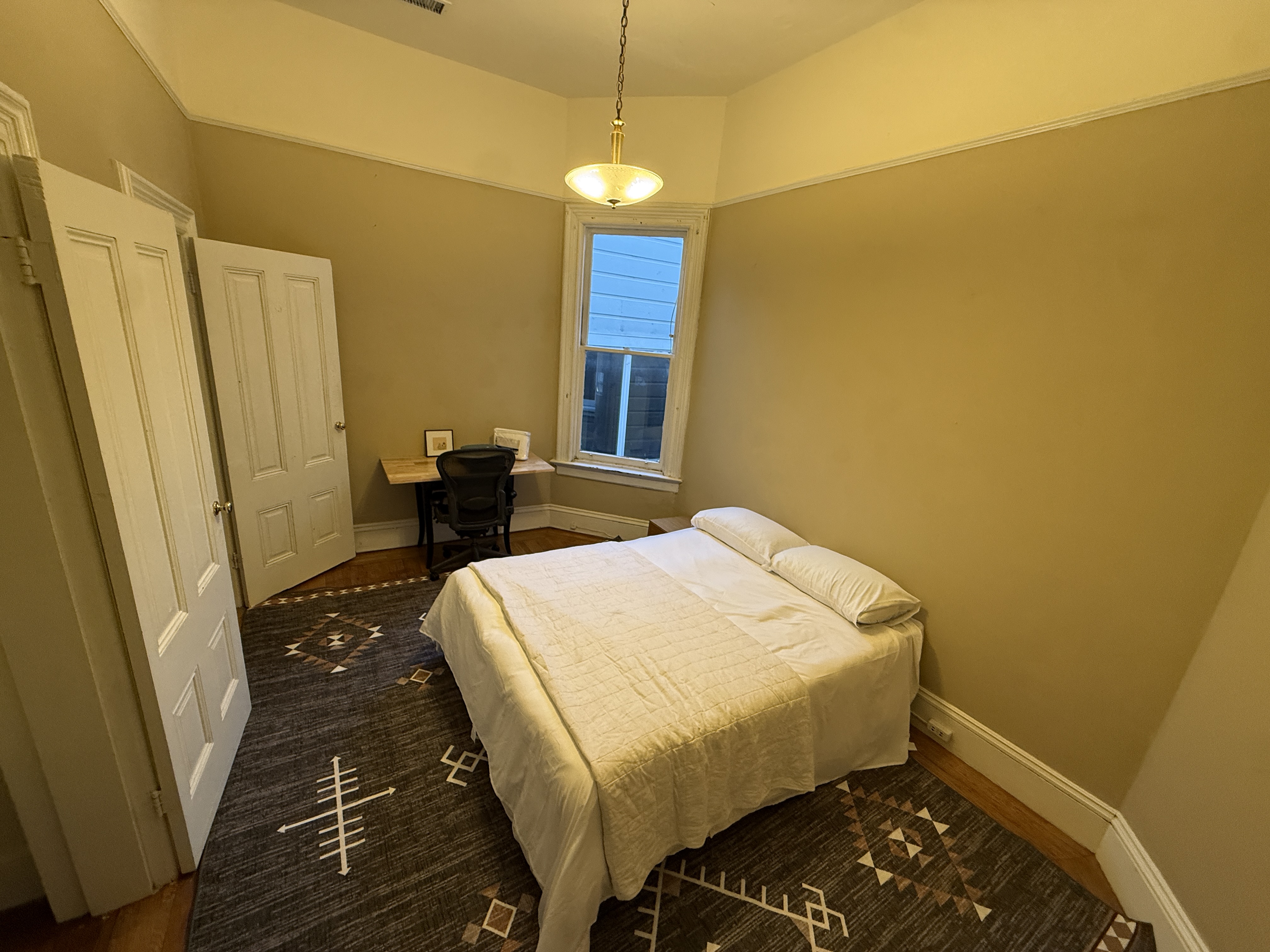 Bedroom with desk area and pendant light