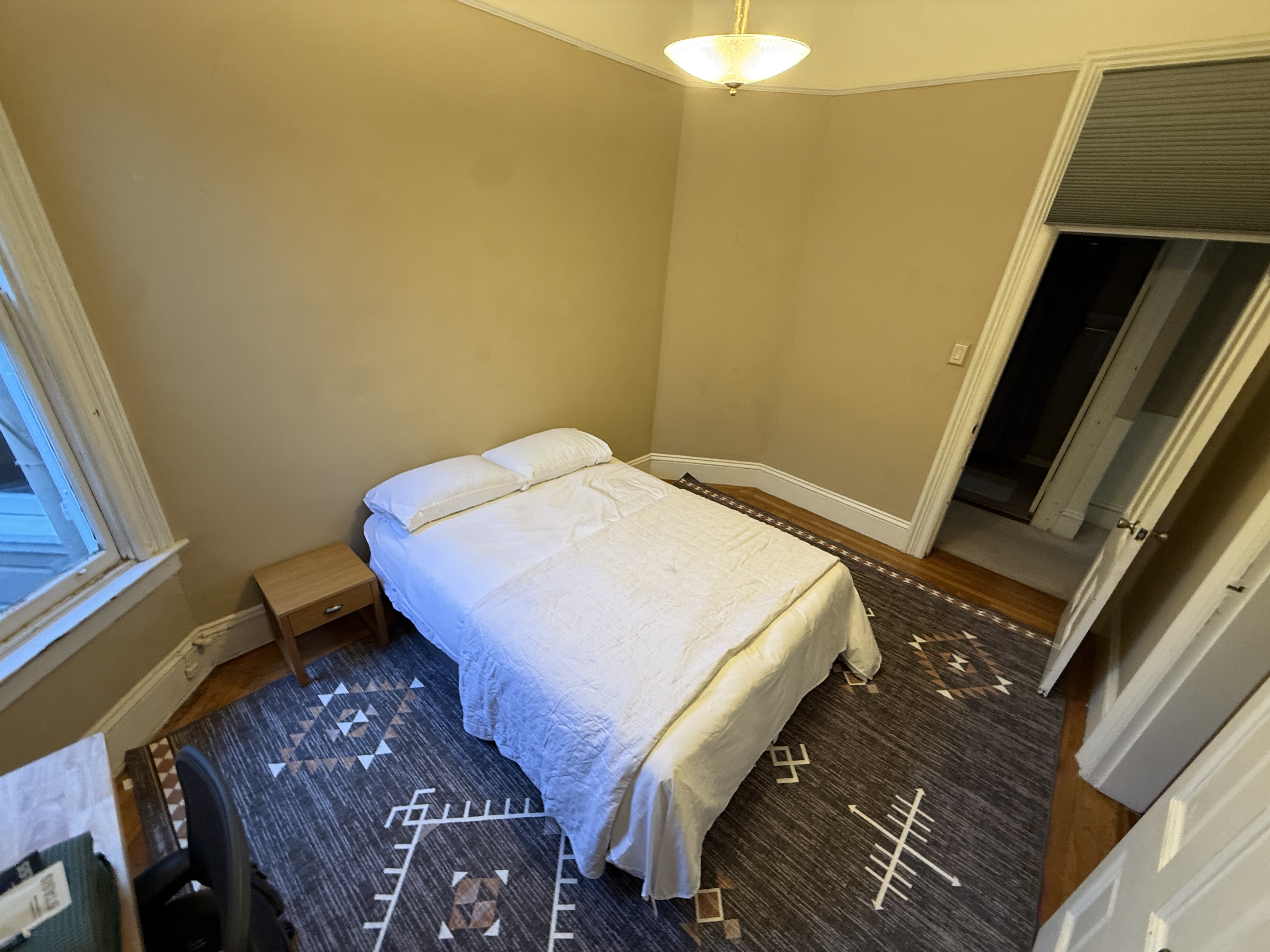 Bedroom with blue patterned rug and minimalist design